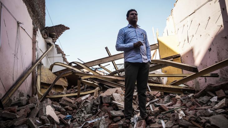 Wakeel Hasan, 45, a rat-hole miner who saved 41 trapped workers during a tunnel rescue, stands on a rubble-filled plot where his house was demolished by Indian authorities. [Md Meharban/Al Jazeera]