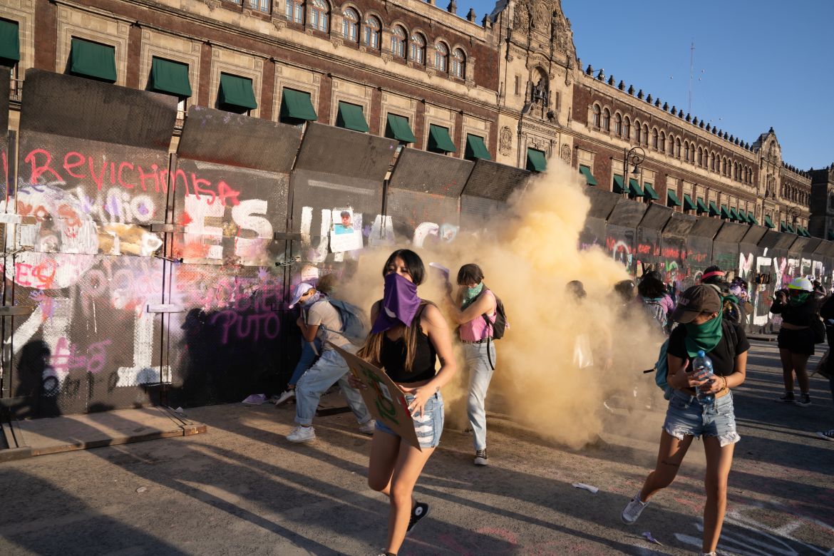 The police periodically sprayed chemical powder through the gaps in the barrier causing the protesters to flee in search of clean air [Lexie Harrison-Cripps / Al Jazeera]