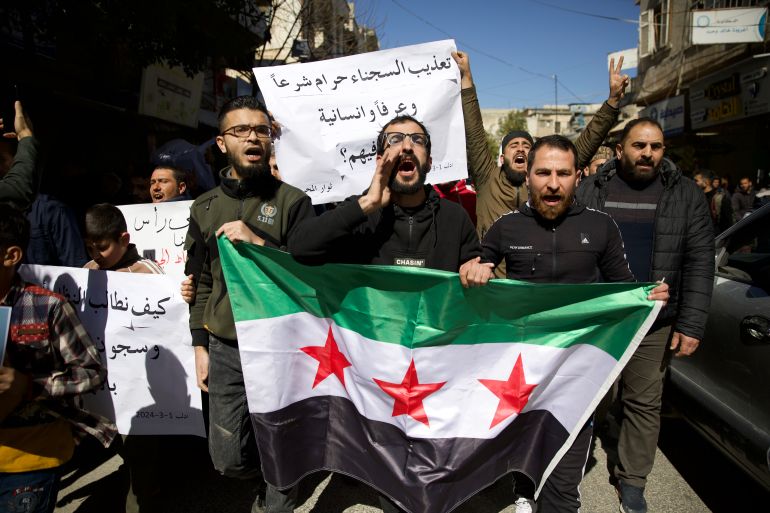 Three men holding a Syrian opposition flag