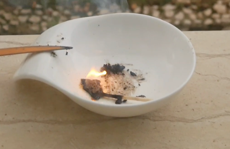 A sample of white phosphorus aflame in a dish