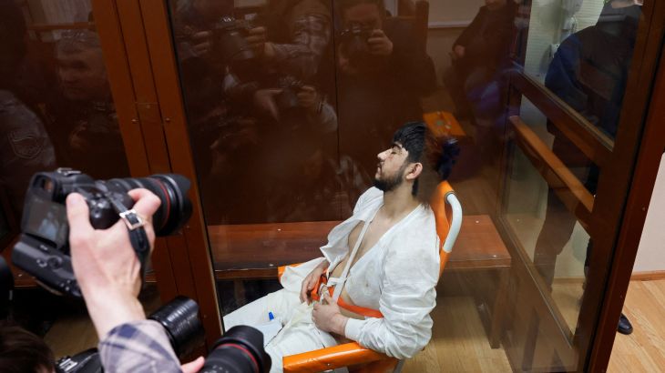 Muhammadsobir Fayzov, a suspect in the shooting attack at the Crocus City Hall concert venue, sits in a medical transport chair behind a glass wall of an enclosure for defendants before a court hearing at the Basmanny district court in Moscow, Russia March 25, 2024. REUTERS/Shamil Zhumatov