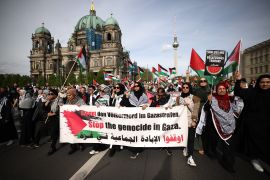 Participants carry a banner reading &quot;Stop the genocide in Gaza&quot; as they walk in front of the Berlin Cathedral (L) and the TV tower (R) during a rally in reaction to the ban of the Palestine Congress in Berlin, Germany, April 13, 2024 [Clemens Bilan/EPA-EFE] (EPA)