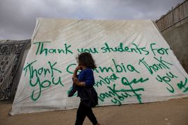 An internally displaced Palestinian child walks past a tent with a thank you message dedicated to students at Columbia University in New York, at the Rafah refugee camp on April 27, 2024. Protests erupted at Columbia and quickly spread through college campuses across the United States as students call on universities to divest from companies that provide arms to Israel [Haitham Imad/EPA-EFE]