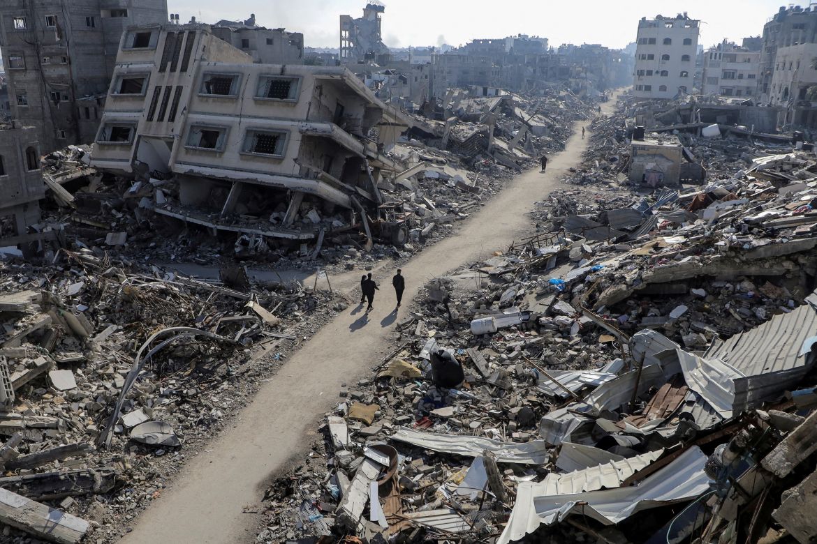 Palestinians walk past destroyed houses, amid the ongoing conflict between Israel and Hamas, in Jabalia refugee camp, in the northern Gaza Strip February 22