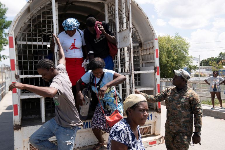 Haitian citizens get off a truck to be sent back to Haiti from the Dominican Republic