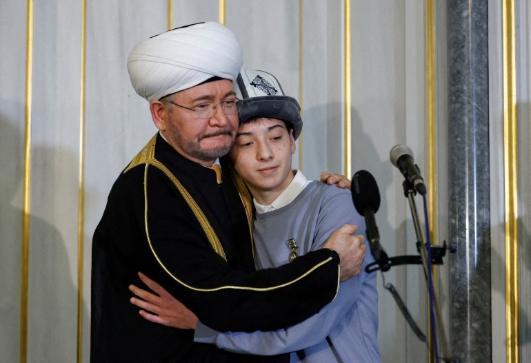 Chairman of the Council of Muftis of Russia Ravil Gainutdin embraces Islam Khalilov, a fifteen-year-old Muslim boy and a cloakroom worker at the Crocus City Hall who saved dozens of people from fire by showing them emergency exits during an attack by gunmen on the concert venue, during a ceremony to award Islam Khalilov at the Moscow Cathedral Mosque in the city of Moscow, Russia, March 29, 2024. REUTERS/Maxim Shemetov