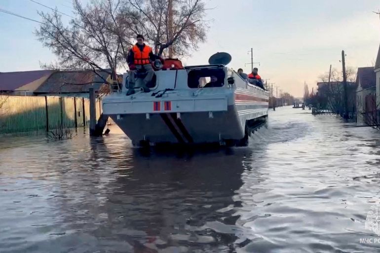 Rescuers search for residents to evacuate as they drive in a flooded residential area in the city of Orsk, Russia, April 6, 2024