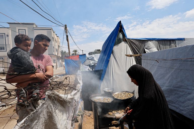 A displaced Palestinian family makes traditional cakes as they prepare for the Eid al-Fitr holiday