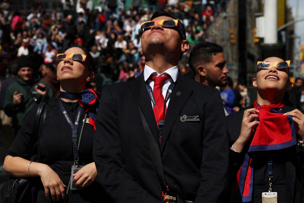 People look up through special glasses at the eclipse.