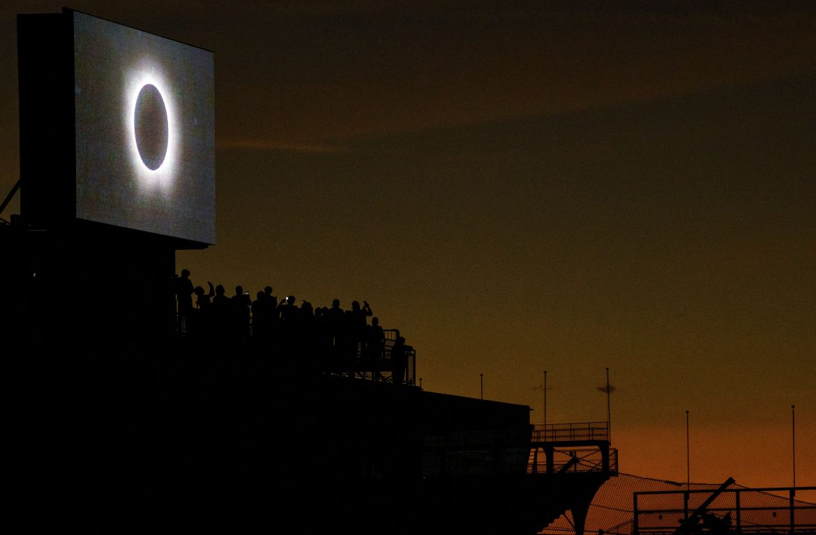 A screen shows the solar eclipse at the Indianapolis Motor Speedway.