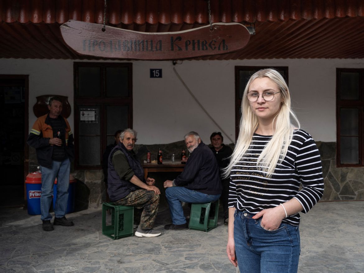 Marija Jankucic, 20, who is a student, poses for a picture in front of the grocery shop where she works, in the village of Krivelj, Serbia, April 3, 2024