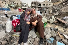 Palestinians sit on the rubble of their home after an Israeli attack in Nuseirat in the central Gaza Strip on April 18, 2024 [Doaa Rouqa/Reuters]