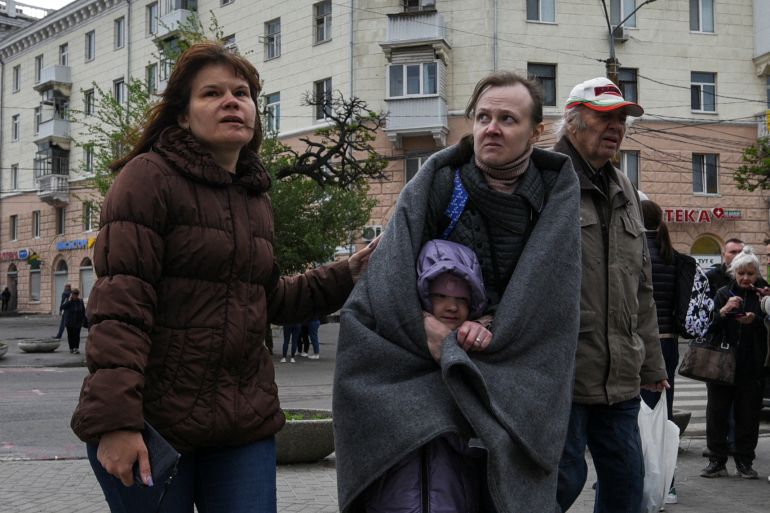 Local residents stand at a site of an apartment building hit by a Russian missile strike, amid Russia's attack on Ukraine, in Dnipro, Ukraine April 19, 2024. REUTERS/Mykola Synelnykov