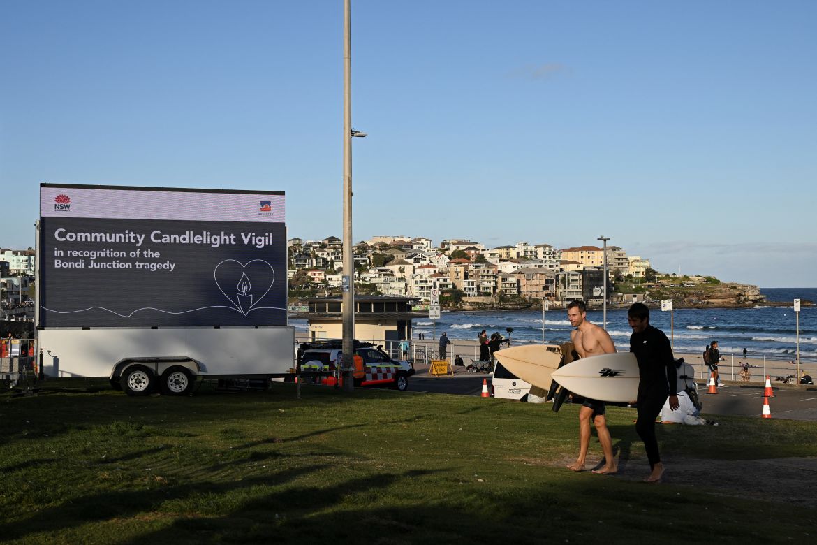 Surfers walk at Bondi Beach before the Community Candlelight Vigil begins, recognising the victims of a fatal stabbing attack at Bondi Junction Westfield shopping centre, in Sydney, Australia, April 21