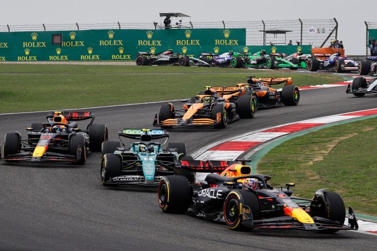 Max Verstappen leads Fernando Alonso and Sergio Perez on the racetrack.