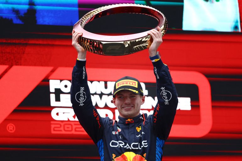 Max Verstappen holds the trophy.