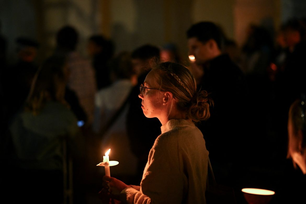 A woman holds a candle during the Community Candlelight Vigil, recognising the victims of a fatal stabbing attack at Bondi Junction Westfield shopping centre, in Sydney, Australia, April 21