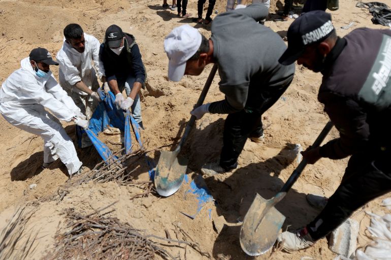 People work to move into a cemetery bodies of Palestinians killed during Israel's military offensive and buried at Nasser hospital, amid the ongoing conflict between Israel and the Palestinian Islamist group Hamas, in Khan Younis in the southern Gaza Strip, April 21