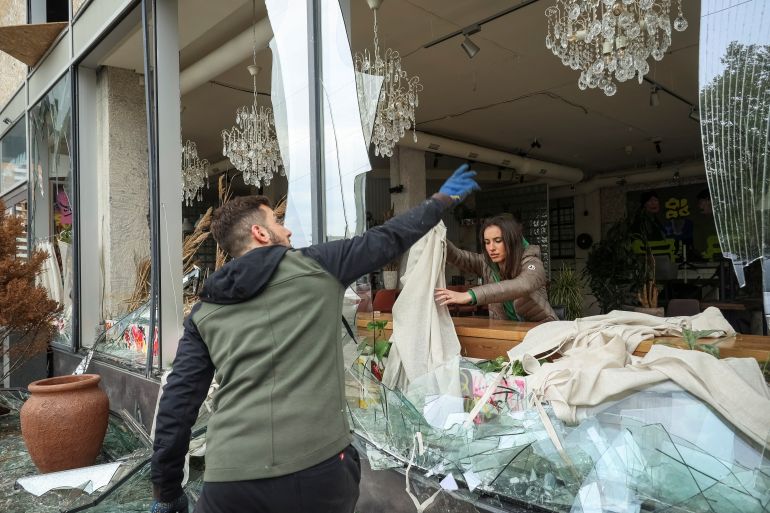 People remove shards of glass from broken windows of a store damaged by a Russian missile strike in Kharkiv, amid Russia's attack on Ukraine April 24, 2024. REUTERS/Sofiia Gatilova