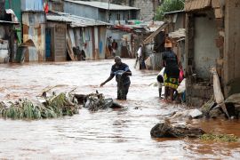 Mathare residents wade through floodwaters as they recover their belongings after the Nairobi river burst its banks [Monicah Mwangi/Reuters]