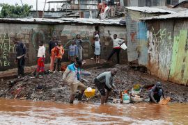 Kenyans wash belongings recovered from their flooded house after the Nairobi River burst its banks within the Mathare Valley settlement in Nairobi [Monicah Mwangi/Reuters]