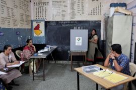 A woman smiles as she speaks with the election official while voting at a polling station, during the second phase of the general elections, at Bengaluru, in Karnataka, India [Navesh Chitrakar/Reuters]