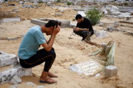 The uncle of Sabreen al-Rouh, a Palestinian baby, who died a few days after she was saved from the womb of her dying mother Sabreen al-Sakani, crouches next to the child&#039;s grave in Rafah in the southern Gaza Strip, on April 26, 2024 [Mohammed Salem/Reuters]