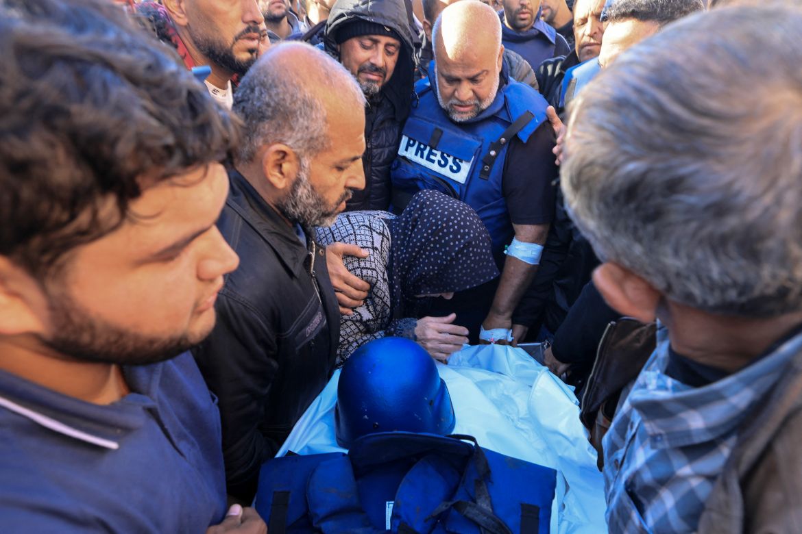 Colleagues and family members mourn over the body of Al Jazeera cameraman Samer Abu Daqa, who was killed during Israeli bombardment, during his funeral in Khan Yunis on the southern Gaza Strip on December 16