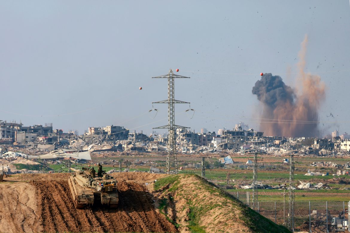 This picture taken from a position in southern Israel, on the border with Gaza shows smoke billowing over the Palestinian territory during Israeli bombardment as an Israeli tank takes position on January 16