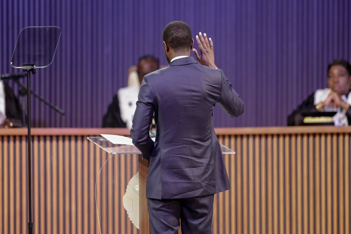 Bassirou Diomaye Faye (C) raises his hand as he is sworn in as Senegal's President at an exhibition centre in the new town of Diamniadio near the capital Dakar