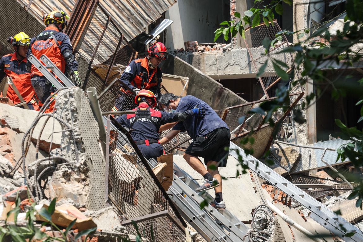 Rescuers helping a man from a damaged building in New Taipei City