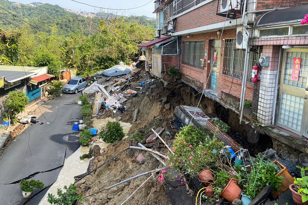 Damage to buildings in Xindian district of New Taipei City, The area is hilly and hte land has fallen away from the building leaving the foundations exposed.
