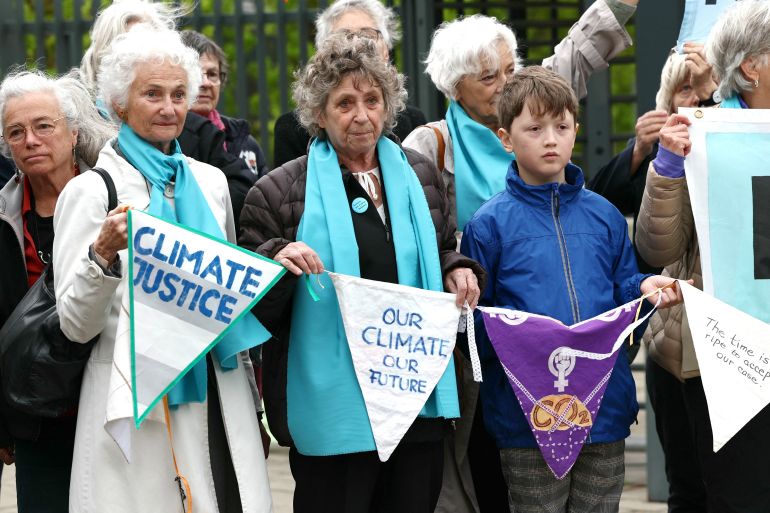 Protesters hold pennants during a rally before the European Court of Human Rights issued three verdicts related to climate change, in Strasbourg, France