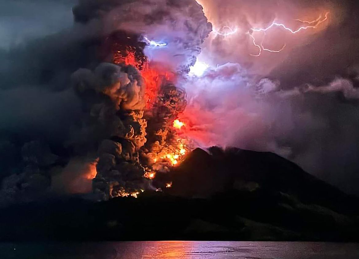 This handout photograph taken and released by the Center for Volcanology and Geological Hazard Mitigation on April 17, 2024, shows Mount Ruang spewing hot lava and smoke as seen from Sitaro, North Sulawesi