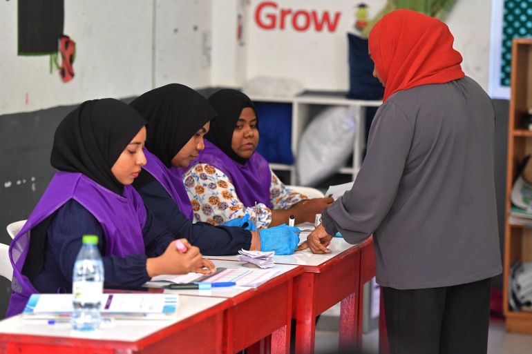A voter casts her ballot in parliamentary elections in Maldives
