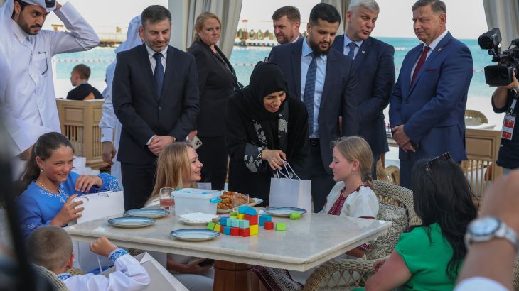 Qatari Minister of State for International Cooperation Lolwah Al-Khater (L) welcomes Ukrainian children and their framilies, flanked to her right by Human Rights Commissioner in the Ukrainian Parliament Dmytro Lubinets in Doha on April 24, 2024.