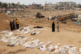 People gather near bodies lined up for identification after they were unearthed from a mass grave found in the Nasser Medical Complex in the southern Gaza Strip on April 25, 2024, following the withdrawal of Israeli forces [File: AFP]
