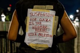 A protester at Columbia University in New York wears the university&#039;s disciplinary warning covered by support in red for Palestinians in Gaza [Alex Kent/Getty Images via AFP]