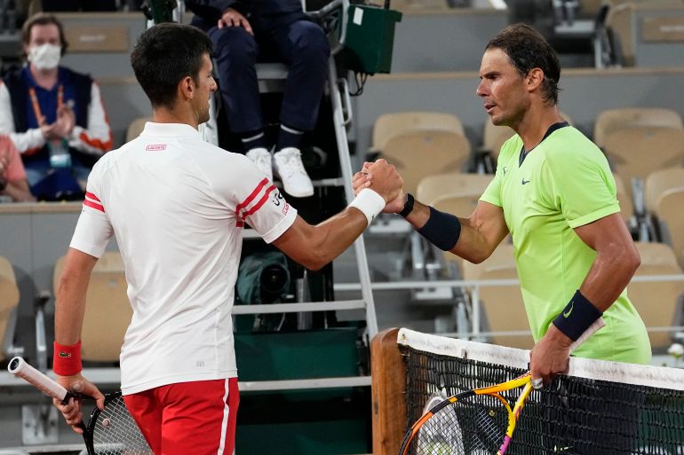 Novak Djokovic shakes hands with Rafael Nadal courtside at the 2021 French Open.