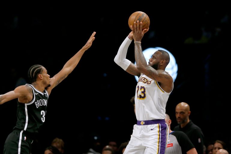 Los Angeles Lakers forward LeBron James makes a 3-point basket over Brooklyn Nets center Nic Claxton.
