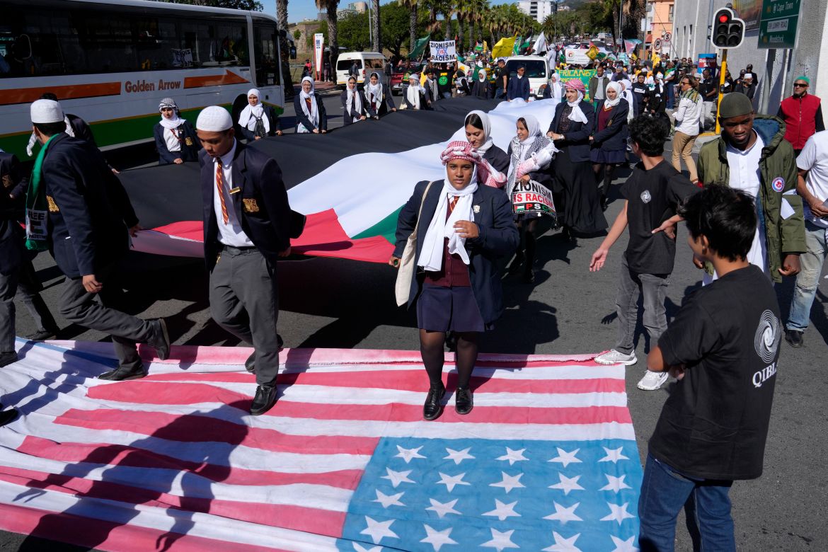 Pro-Palestinian supporters walk over American and Israeli flags as they take part in a Quds Day protest in Cape Town, South Africa