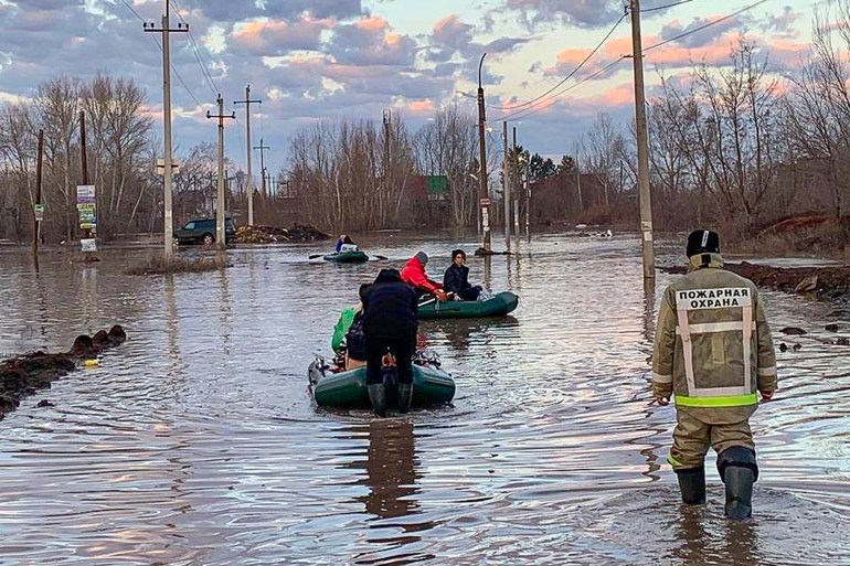 In this photo taken and released by the Administration of the city of Orenburg telegram channel on Friday, April 5, 2024, people use boats while evacuating after a part of a dam burst causing flooding, in Orsk, Russia. 