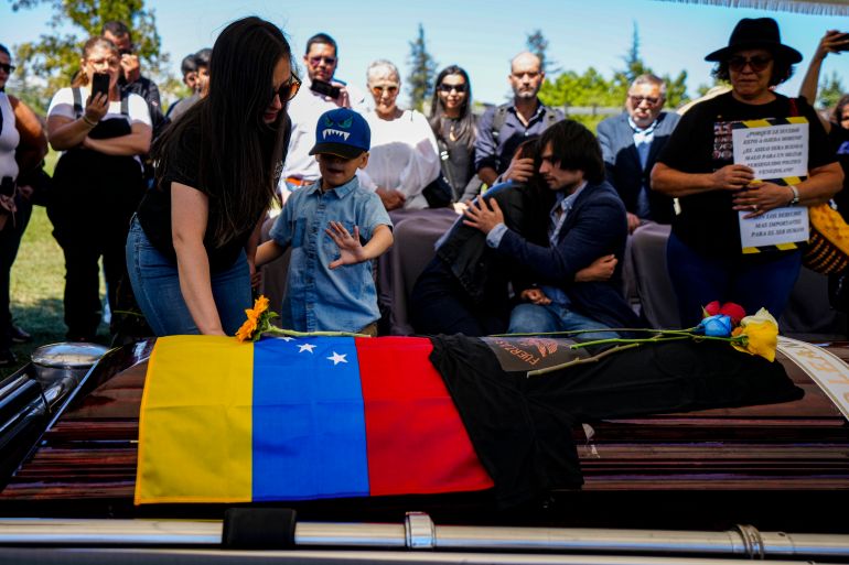 A Venezuelan flag is draped over a coffin.