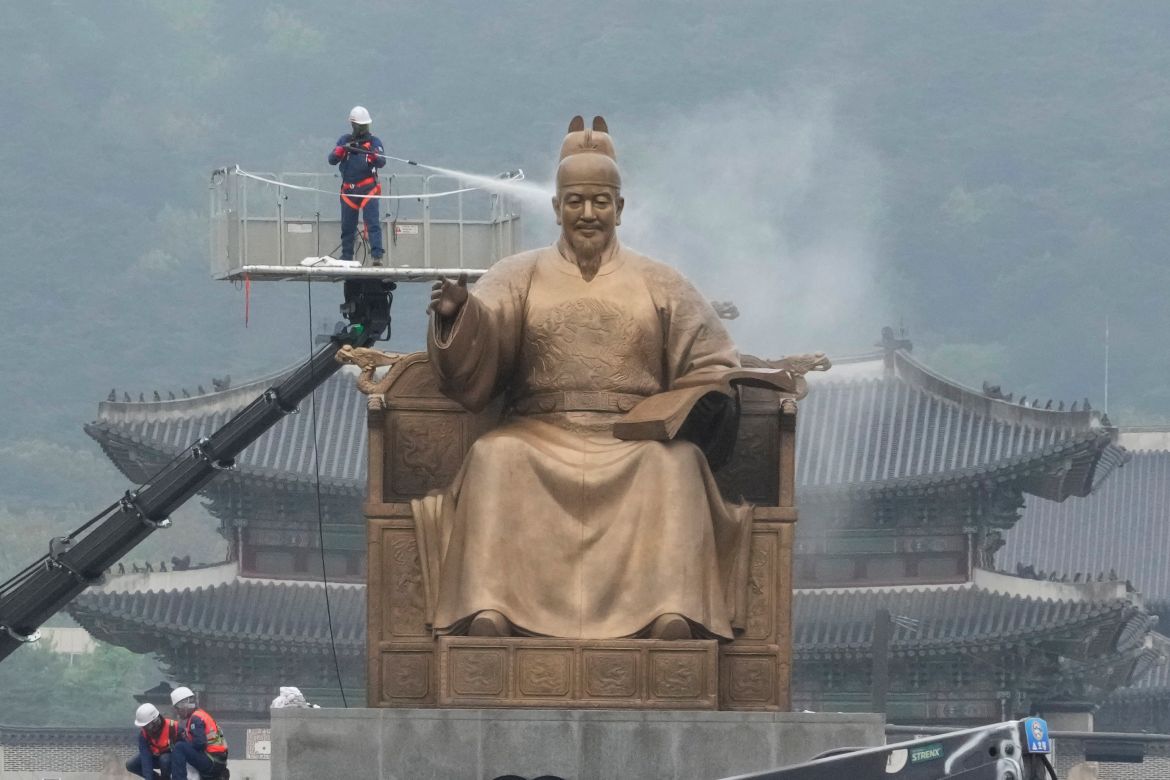 A worker sprays water onto the statue of King Sejong for a spring cleaning at the Gwanghwamun Plaza in Seoul, South Korea, Tuesday, April 16