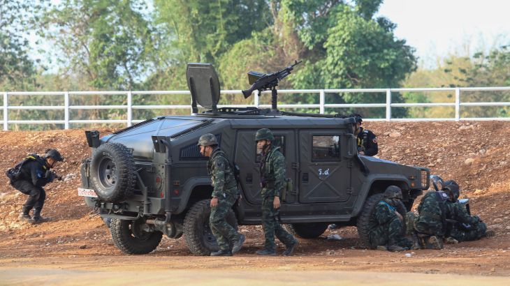 A Thai military armored vehicle takes a position with sounds of explosions and gunshots along the Moei river,