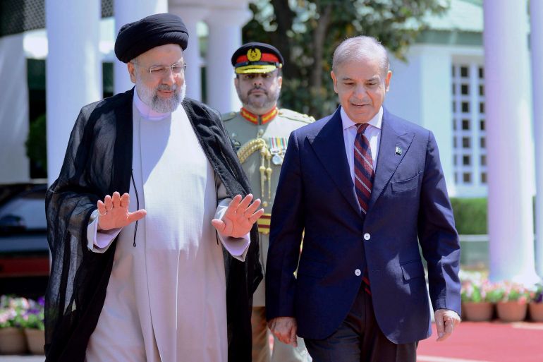 In this photo released by Prime Minister Office, Iranian President Ebrahim Raisi, left, walks with Pakistan's Prime Minister Shehbaz Sharif during a welcome ceremony in the prime minister house in Islamabad, Pakistan.