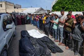 Mourners pray over the bodies of Palestinians who were killed in an Israeli air attack on Nuseirat [Abdel Kareem Hana/AP Photo]