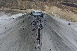 Hindu devotees climb stairs to reach the summit of a mud volcano to start their pilgrimage at one of the faith&#039;s holiest sites in Pakistan&#039;s southwestern Balochistan province. [Mohammad Farooq/AP Photo]