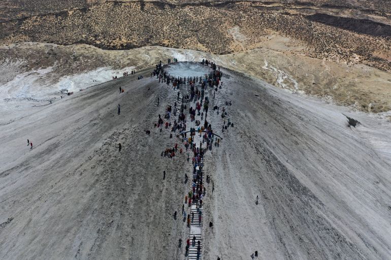 In this aerial photo taken from a drone, Hindu devotees climb stairs to reach on top of a mud volcano to start Hindu pilgrims religious' rituals for an annual festival in an ancient cave temple of Hinglaj Mata in Hinglaj in Lasbela district in Pakistan's southwestern Baluchistan province, Friday, April 26