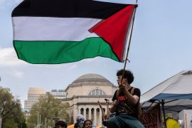 A student waves a large Palestinian flag on the Columbia University campus in New York, April 29, 2024 [Stefan Jeremiah/AP Photo]